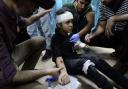 Palestinian medics treat a child wounded in the Israeli bombardment on the Bureij refugee camp in Gaza