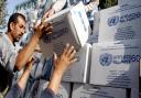 Palestinians receive food aid donated for refugees distributed by Unrwa in the West Bank city of Jenin