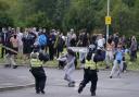 A rioter throws a fence post towards police officers during an anti-migrant rally outside a hotel in Rotherham, South Yorkshire on Sunday