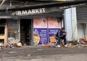 Abdelkader Mohamad Al Alloush sits outside his Belfast shop, which was torched in far-right riots on Saturday