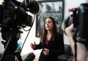 Deputy First Minister Kate Forbes speaks to the media in front of a painting of ship building workers during a visit to Ferguson Marine Port Glasgow in July