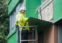 Workers remove potentially dangerous cladding from a tower block