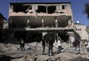 People look at destruction after an Israeli army raid on a Palestinian refugee camp in the West Bank last year