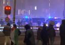 In this image taken from video, a group of pro-Palestinian protesters walk towards police line, with police vans driving in the background, near the stadium in Amsterdam, Netherlands (RTL Nieuws via AP)