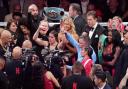 Katie Taylor, centre, celebrates after defeating Amanda Serrano during their undisputed super lightweight title bout (Julio Cortez/AP)