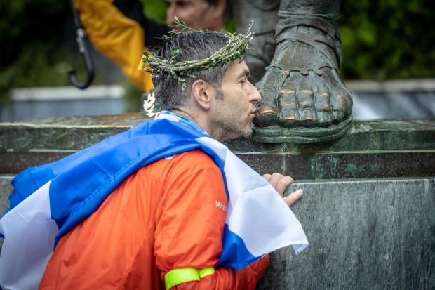 The National: Al kissing the feet of a statue of King Leonidas at the finish line