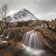 Buachaille Etive Mor and waterfall on River Coupall in winter in Glen Etive near Glencoe (Photo by: Arterra/UIG via Getty Images).