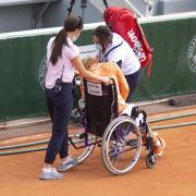 Kiki Bertens leaves the court in a wheelchair