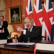 Former UK chief trade negotiator, David Frost looks on as Prime Minister Boris Johnson signs the EU-UK Trade and Cooperation Agreement at 10 Downing Street, Westminster. PA Photo. Picture date: Wednesday December 30, 2020.