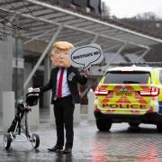 A masked protester at the Scottish Parliament in February, when the Scottish Greens sought an Unexplained Wealth Order against Donald Trump's Scottish golf operations. Pic: Jane Barlow/PA Wire
