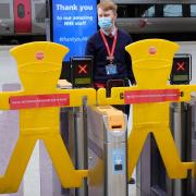 An LNER worker stands by station turnstiles closed due to Covid. The train company had to apologise for giving Scottish law-breaking guidance to cross-border passengers.