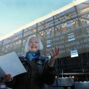 Edinburgh's Makar Christine De Luca reads poetry in front of the UK's largest poem which was unveiled in Edinburgh's Canongate. 'Spiral' has been reproduced on a 25x8 metre benner to mark National Poetry Day