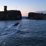 An RNLI boat rushes to help a man who fell from a cliff in Dunbar, East Lothian. Photograph: RNLI/Douglas Wight