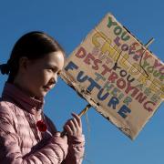 A climate protester with a sign: 'You say you love your children but you are destroying their future'
