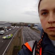 A protester who has climbed a gantry on the M25 between junctions six and seven in Surrey