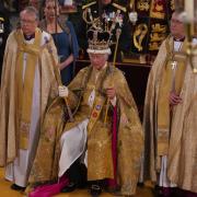 The King seated in St Edward’s Chair, also known as the Coronation Chair, wearing St Edward’s Crown and holding The Sovereign’s Sceptre with the Dove (in his left hand) and The Sovereign’s Sceptre with Cross (in his right hand) (Aaron Chown/PA)