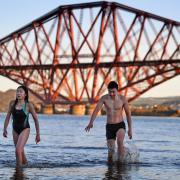 Members of the public brave cold waters in River Forth to take a New Year dip in front of the Forth Rail Bridge on January 1