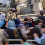 Afghan women and children ride a three-wheeler vehicle near the US embassy in Kabul on August 15, 2023, as Taliban celebrates the second anniversary of their takeover