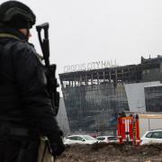A law enforcement officer patrols the scene of the gun attack at the Crocus City Hall concert hall in Krasnogorsk, outside Moscow