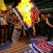 Protesters in Tehran burn American and Israeli flags
