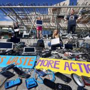 Campaigners pose with a pile of electronic waste outside the Scottish Parliament
