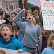 Schoolchildren take part in a 'die-in' climate change protest campaigning against the use of fossil fuels