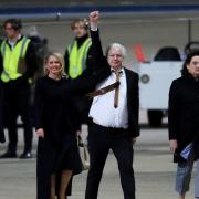 WikiLeaks founder Julian Assange gestures as he arrives at Canberra Airport on June 26, 2024