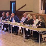 A closer view of the convenor and speakers at the hustings.Seated at the table in the middle is convenor Ron McAulay, Chairman of Strathpeffer and District Community Council.Surrounding him, left to right:Maree Todd (SNP)David Green (Scottish Lib