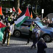 The new Prime Minister’s car convoy was surrounded by pro-Palestine supporters who were waving flags and placards which read 'ceasefire now'