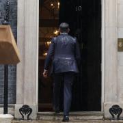 Rishi Sunak, soaked in rain, walks back into No 10 after calling the election