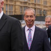 Nigel Farage pictured with other Reform MPs walking into the Houses of Parliament