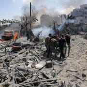 Palestinians evacuate a body from a site hit by an Israeli bombardment on Khan Younis, southern Gaza Strip