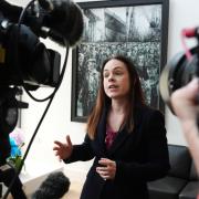 Deputy First Minister Kate Forbes speaks to the media in front of a painting of ship building workers during a visit to Ferguson Marine Port Glasgow in July