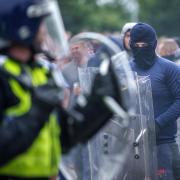 Riot police officers push back anti-migration protesters outside the Holiday Inn Express Hotel which is housing asylum seekers in Rotherham