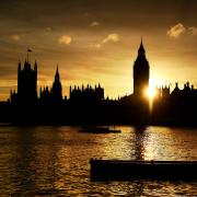 The sun sets behind the Houses of Parliament in London