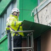 Workers remove potentially dangerous cladding from a tower block