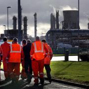 Workers walk through the Grangemouth oil refinery in Falkirk