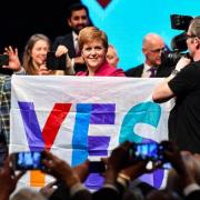 Former first minister Nicola Sturgeon  holds a Yes flag at SNP conference in 2019