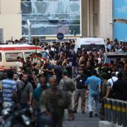 Ambulances are surrounded by people at the entrance of the American University of Beirut Medical Center