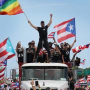 Singer Ricky Martin waves a flag as he joins with thousands of other people as they fill the Expreso Las AmÃ 	©ricas highway calling for the ouster of Gov. Ricardo A. RossellÃ 	³ in San Juan, Puerto Rico (Photo by Joe Raedle/Getty