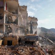 Rescue workers in the rubble of a destroyed building in Barja (Hassan Ammar/AP)