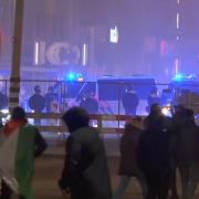 In this image taken from video, a group of pro-Palestinian protesters walk towards police line, with police vans driving in the background, near the stadium in Amsterdam, Netherlands (RTL Nieuws via AP)