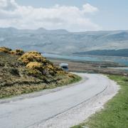 A campervan approaches on the NC500 route in Scotland