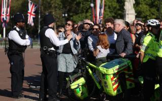 A member of the public argues with police after trying to leave a crowded area at Buckingham Palace