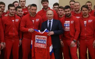 Russian President Vladimir Putin with athletes going to the Winter Olympics to compete under a neutral flag