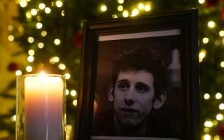 A candle burns next to a photograph of The Pogues frontman Shane MacGowan at the Mansion House, in Dublin, after a book of condolence was open by the Lord Mayor of Dublin
