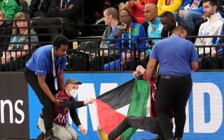 Demonstrators are removed by stewards ahead of the men's 3000 metres during day two of the World Indoor Athletics Championships