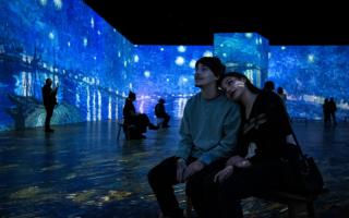 Two people enjoying the Beyond Van Gogh: The Immersive Experience