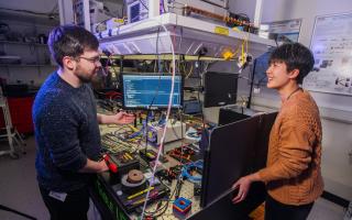 PhD students Arran Sykes and Harmony Li discussing quantum internet