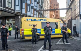 Police officers and a police van block the vehicle entrance at Liverpool Magistrates' Court